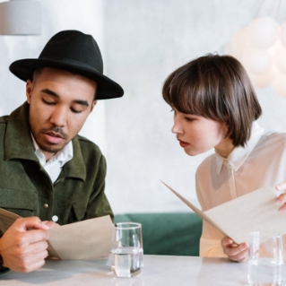 A couple struggling to choose wine from a menu